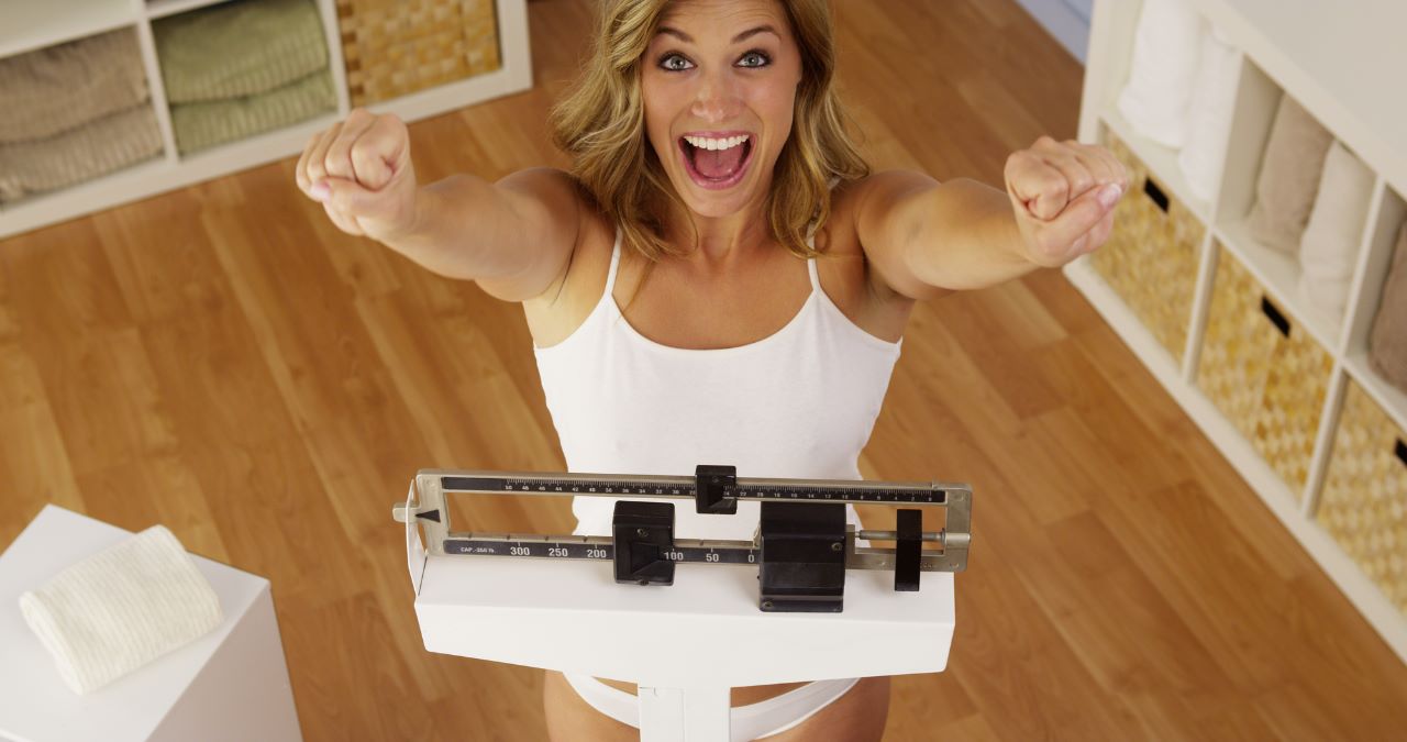 fit-woman-happy-weighing-scale